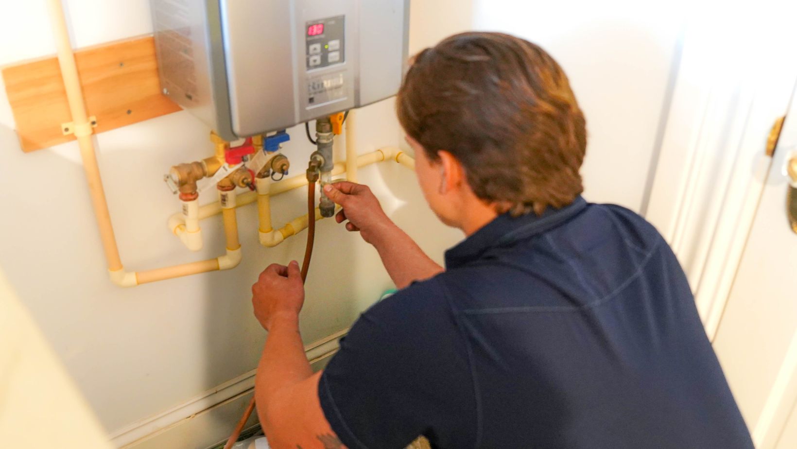 plumber connecting water heater lines and valves during plumbing service